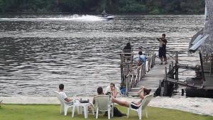 a group of people sitting in chairs on a dock at Bamboo House Resort in Kanchanaburi City