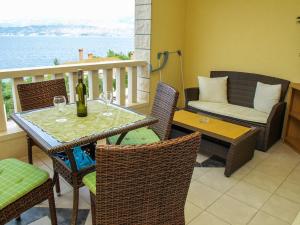 un patio con una mesa con copas de vino y un sofá en Lozna Apartment, en Postira