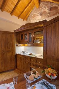 eine Küche mit Holzschränken und einem Tisch mit Obst in der Unterkunft Residence San Lorenzo in Verona