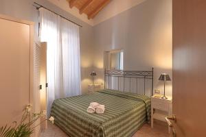 ein Schlafzimmer mit einem Bett mit zwei Handtüchern darauf in der Unterkunft Residence San Lorenzo in Verona