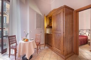 Zimmer mit einem Tisch, einem Schrank und einem Schlafzimmer in der Unterkunft Residence San Lorenzo in Verona