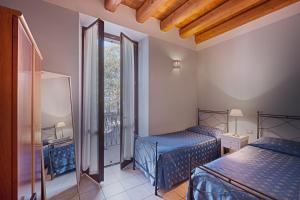 ein kleines Zimmer mit 2 Betten und einem Fenster in der Unterkunft Residence San Lorenzo in Verona