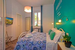 Schlafzimmer mit einem Tisch und einem blauen und weißen Bett in der Unterkunft Allegra's House Caracciolo in Rom