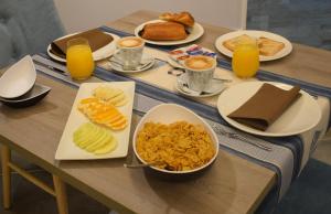 - une table avec des assiettes de produits pour le petit-déjeuner et du jus d'orange dans l'établissement Hotel Rural Seixalvo, à Sanxenxo