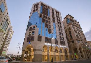 a tall building in the middle of a city at Anwar Al Zahraa Hotel in Medina