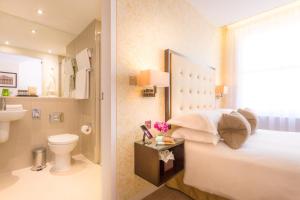 a bathroom with a bed and a toilet and a sink at Ten Manchester Street Hotel in London