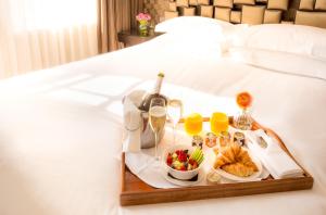 a tray of food and wine on a bed at Ten Manchester Street Hotel in London +53 photos