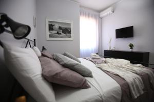 ein Schlafzimmer mit einem großen weißen Bett mit Kissen in der Unterkunft AmalfiCoastApartments in Salerno