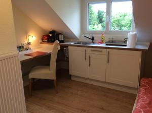 a kitchen with a sink and a desk with a chair at Heidelberg Appartements Berger in Heidelberg