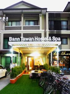 un hotel con un montón de bicicletas estacionadas frente a él en Bann Tawan Hostel Chiang Rai, en Chiang Rai