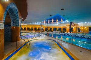 - une grande piscine dans un grand bâtiment avec une piscine dans l'établissement Hotel Gołębiewski Mikołajki, à Mikołajki