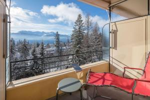 a room with a balcony with a table and a chair at Crans-Montana Youth Hostel in Crans-Montana