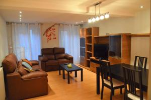 a living room with a couch a table and a television at En el Centro de Pamplona, La Taconera in Pamplona