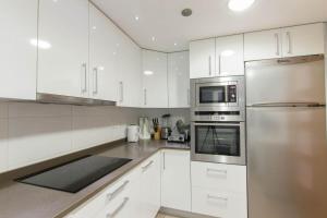 a kitchen with white cabinets and a stainless steel refrigerator at En el Centro de Pamplona, La Taconera in Pamplona