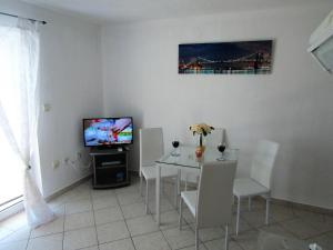 jadalnia ze stołem i telewizorem w obiekcie Apartments Kokor w mieście Vodice