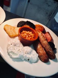 a plate of breakfast food with eggs sausage and beans at Ship Inn in Aberporth