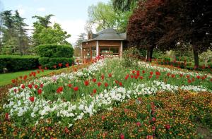 a garden with flowers in front of a gazebo at En el Centro de Pamplona, La Taconera in Pamplona