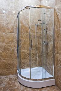 a shower with a glass door in a bathroom at Hotel 8th Mile in Dnipro