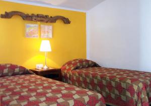 a hotel room with two beds and a table with a lamp at Colores en el Viento in Frigiliana +24 photos