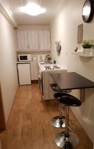 a kitchen with a table and two bar stools at Sigurhæð - Apartment with all within your reach in Ísafjörður