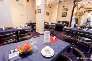 a dining room with blue tables and stools with food on them at Belmont Hotel in Blackpool