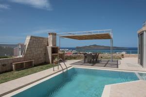 アギア・マリーナ・ネア・キドニアスにあるPantanassa Villa Thaliaの海の景色を望む家の中のスイミングプール