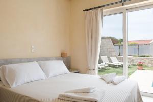 a bedroom with a bed and a large window at Pantanassa Villa Thalia in Agia Marina Nea Kydonias