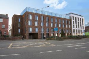 a large brick building on a street with a parking lot at Maldron Hotel Kevin Street in Dublin