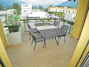 patio ze stołem i krzesłami na balkonie w obiekcie Casa Robinia App 4000 w mieście Locarno