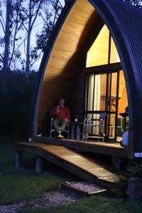 a man sitting in a window of a house at Wetland View Park in Anatori