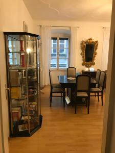 a dining room with a table and chairs and a bookcase at The Barts City Center - Self Check-in in Vienna