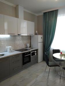 uma cozinha com armários brancos e uma mesa e uma mesa e uma sala de jantar em Astashkina em Odessa