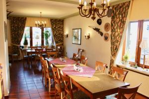 a restaurant with wooden tables and chairs and windows at Hotel Gasthof Klusmeyer in Bielefeld