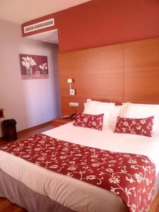 a hotel room with a large bed with pillows at Hotel Restaurante El Tollo in Utiel