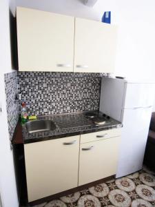 a small kitchen with white cabinets and a sink at Apartment old town in Primošten +8 photos
