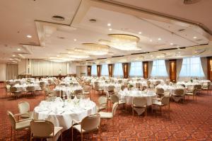 einen großen Bankettsaal mit weißen Tischen und Stühlen in der Unterkunft Maritim Hotel Magdeburg in Magdeburg
