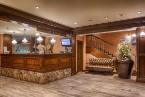 a lobby with a bar with a bench and stairs at Wellness Hotel Borovica in Štrbské Pleso
