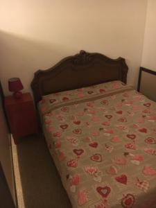 a bed with a bedspread with hearts on it at Europa Red Apartment in Favaro Veneto