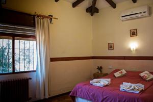 una camera da letto con un letto rosso e una finestra di Hotel Parque Siquiman a Villa Carlos Paz