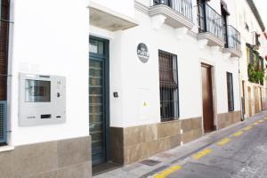 a white building with a sign on the side of a street at Nest Flats Granada in Granada