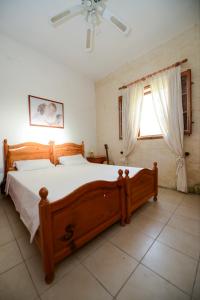 1 dormitorio con cama de madera y ventana en Tal-Masklu farmhouse, en Għarb 33 fotos más