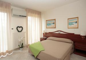 Un dormitorio con una cama con una manta verde. en Residence Dell'Angelo en Ospedaletti