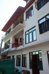 ein weißes Gebäude mit Fenstern und Balkonen in der Unterkunft Howrah Guest House in Srinagar