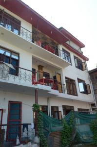 ein großes weißes Gebäude mit Balkonen darauf in der Unterkunft Howrah Guest House in Srinagar