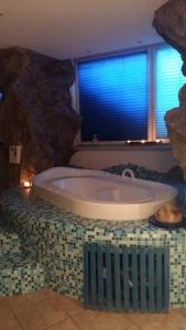 una grande vasca da bagno in una stanza con finestra di Albergo Garni Martina a Carisolo