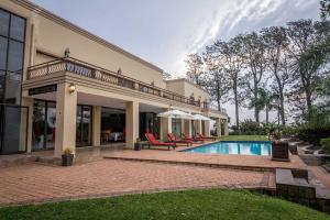 a house with a swimming pool and some chairs at Ebandla Hotel & Conference Centre in Ballito