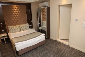 a bedroom with a bed and a dresser at Ankara Gold Hotel in Ankara