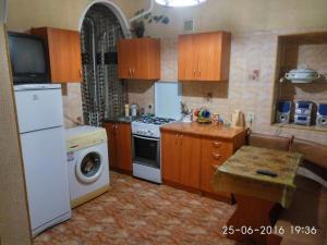 een keuken met een witte koelkast en een fornuis top oven bij квартира in Odessa
