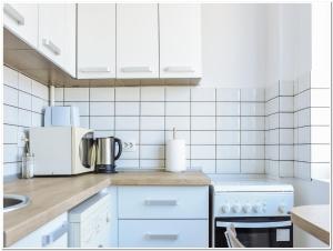 eine Küche mit weißen Geräten und weißen Fliesen in der Unterkunft Regina Elisabeta Apartment in Bukarest