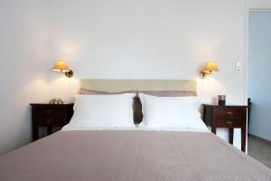 a bedroom with a large bed with two night stands at Tsakanos Apartments in Adamantas